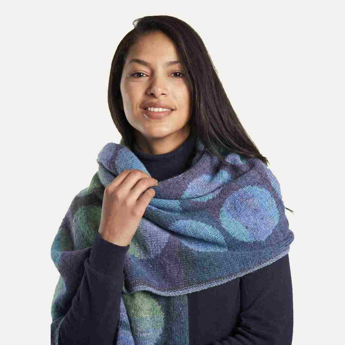 Kaffe fassett Marble wrap kit Woman with dark hair wearing wrap with large polka dots in gradient yarn